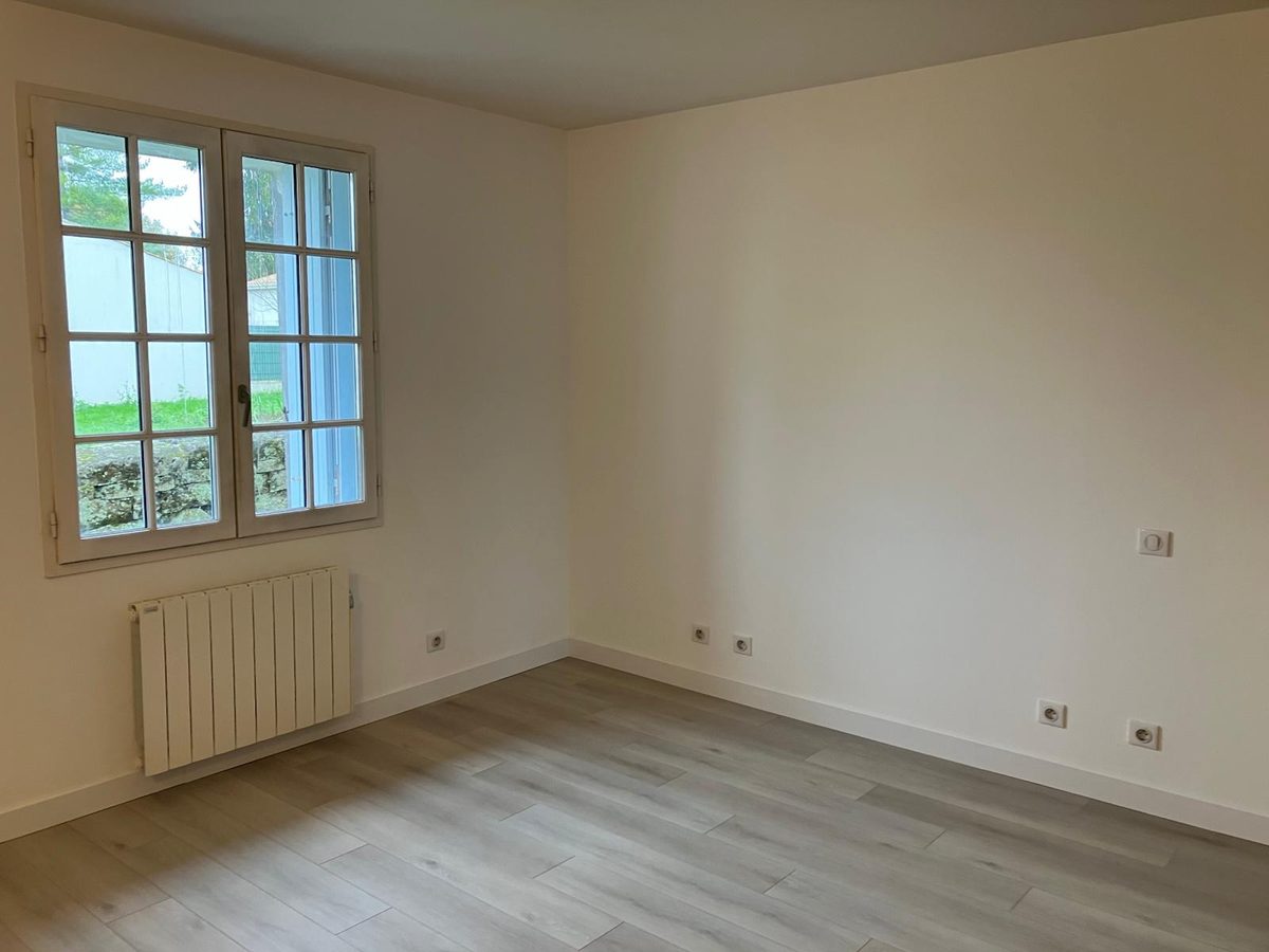 Vue générale de la chambre finie — murs blancs mats et parquet stratifié clair