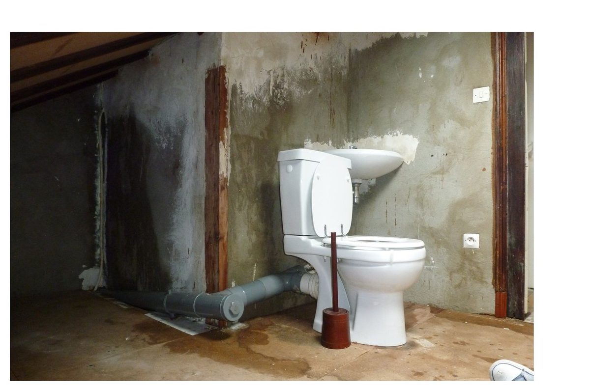 Salle de bain sous combles avant — murs dégradés, sanitaires en place